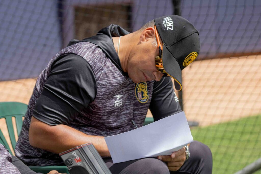 Robinson Chirinos, gerente deportivo de los Leones del Caracas, revisa una hoja durante una práctica del equipo