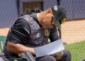Robinson Chirinos, gerente deportivo de los Leones del Caracas, revisa una hoja durante una práctica del equipo