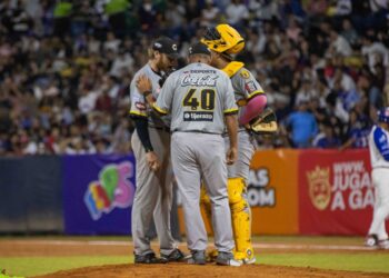 Lanzador, receptor y cuerpo técnico en una visita al montículo del pitcheo de los Leones del Caracas